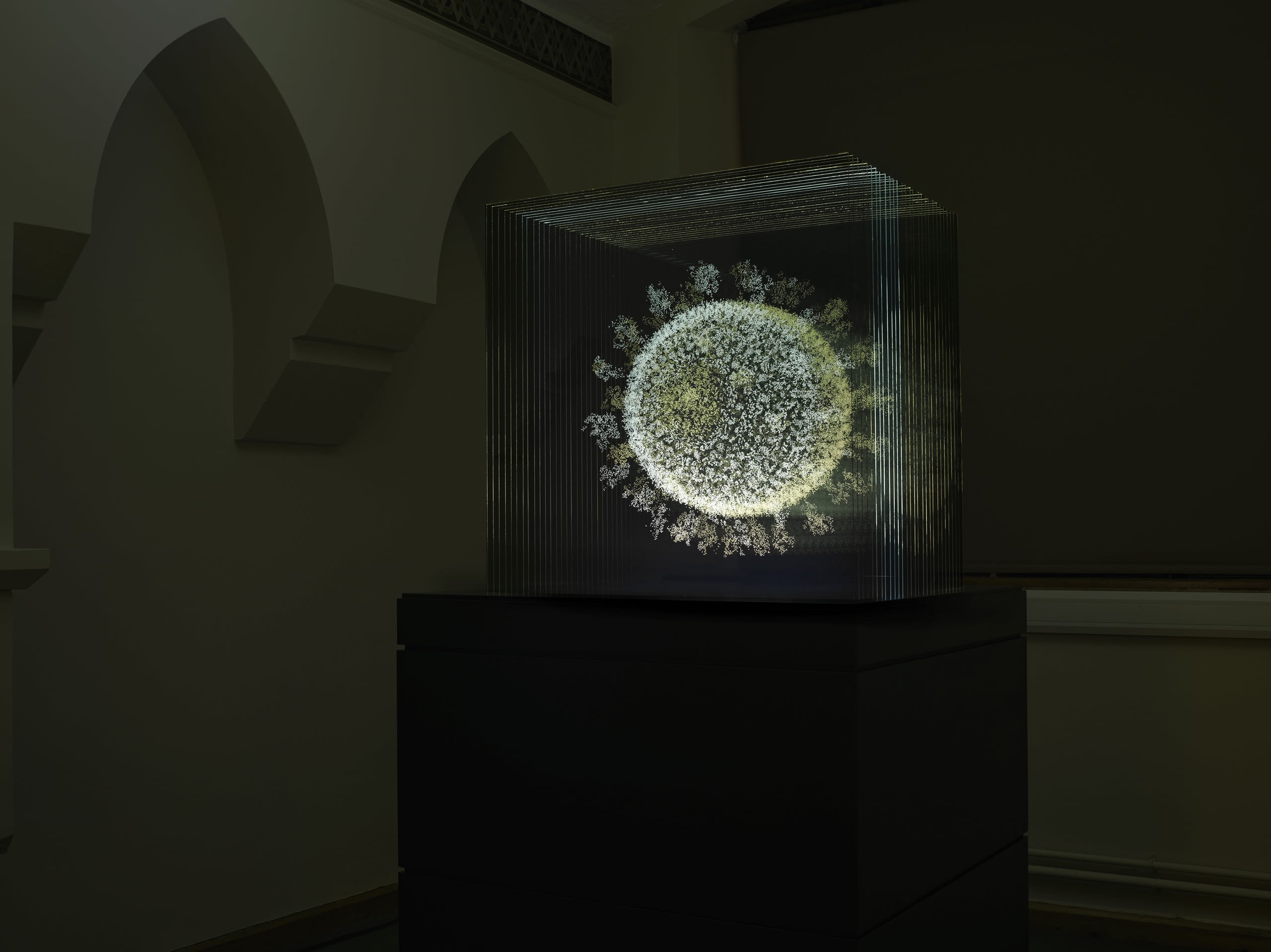 A glowing sphere on a plinth in a darkened room
