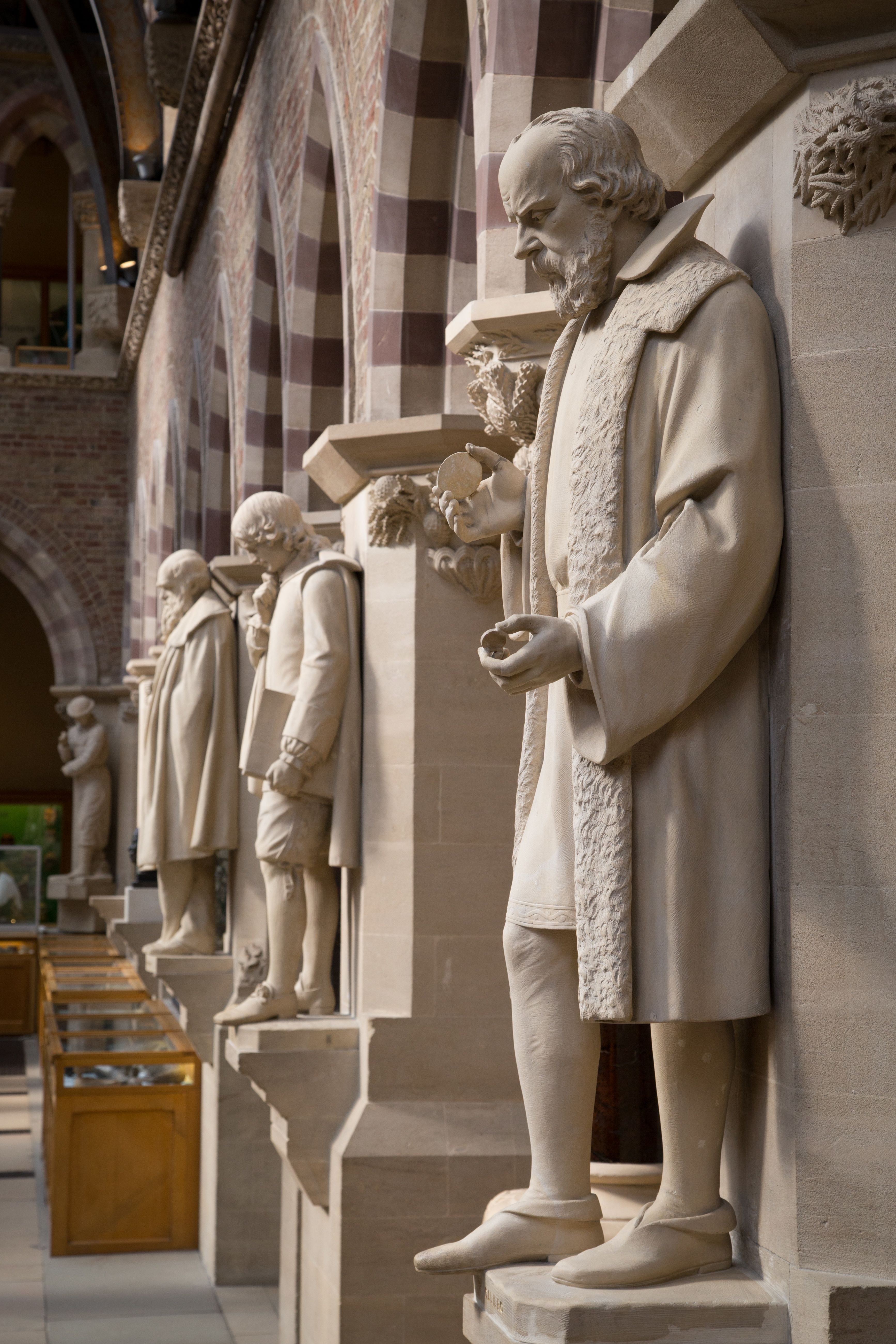 Full-length statues depicting scientists in the central court
